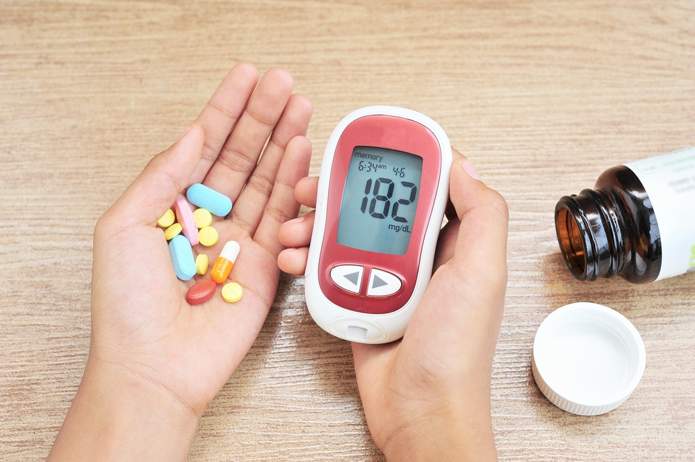 Hand holding a glucose monitor with medication for emergency in Columbus, OH Hand holding a glucose monitor with medication for emergency in Columbus, OH